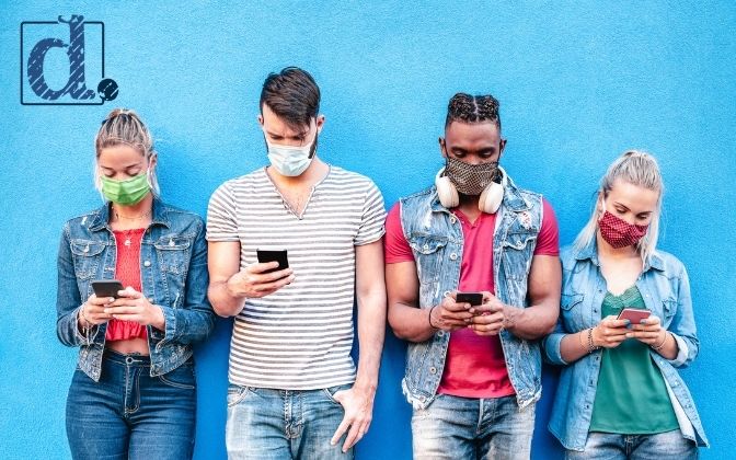 Generation Z members wearing masks and looking at their phones